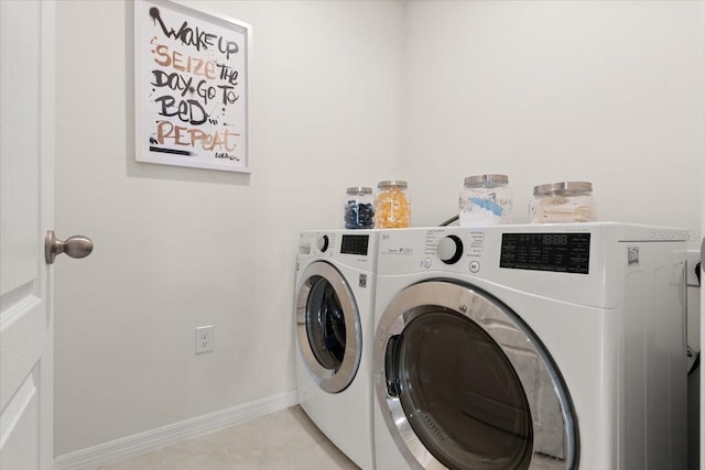 laundry area featuring light tile patterned flooring and washing machine and clothes dryer