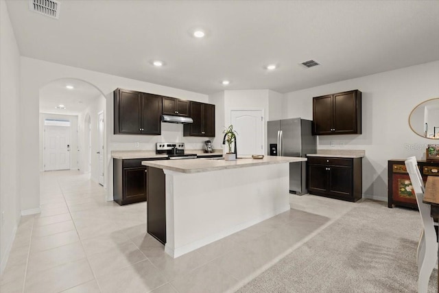 kitchen featuring sink, dark brown cabinets, light tile patterned floors, appliances with stainless steel finishes, and an island with sink