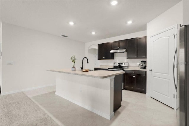 kitchen with dark brown cabinetry, appliances with stainless steel finishes, sink, and a center island with sink