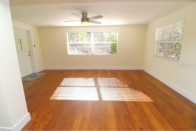 unfurnished room with dark wood-type flooring and ceiling fan