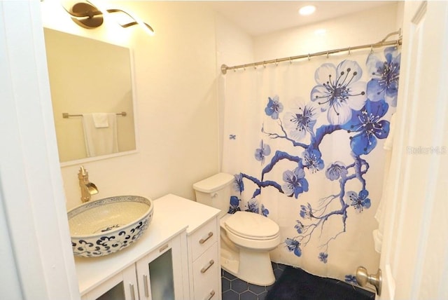 bathroom featuring vanity, tile patterned flooring, toilet, and walk in shower