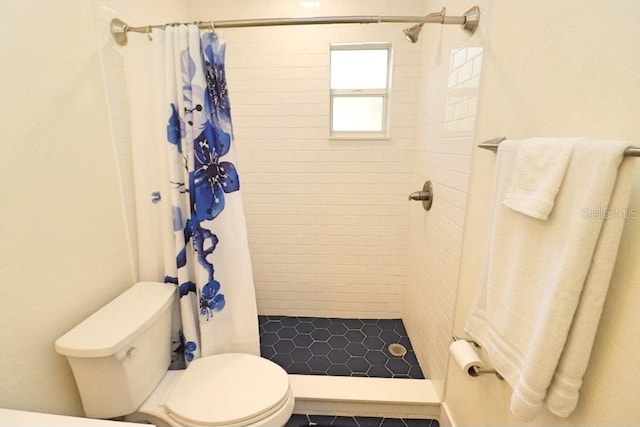 bathroom featuring toilet and walk in shower