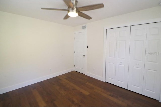 unfurnished bedroom featuring ceiling fan, dark hardwood / wood-style flooring, and a closet