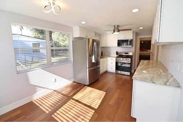 kitchen featuring appliances with stainless steel finishes, dark hardwood / wood-style flooring, light stone countertops, and white cabinets