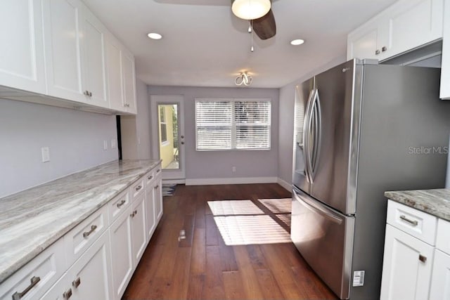 kitchen featuring white cabinetry, stainless steel fridge, and light stone countertops