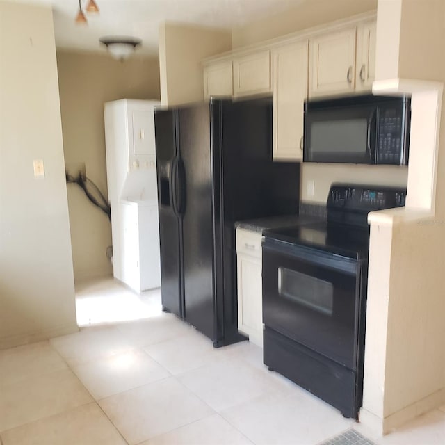 kitchen featuring white cabinetry, light tile patterned floors, and black appliances