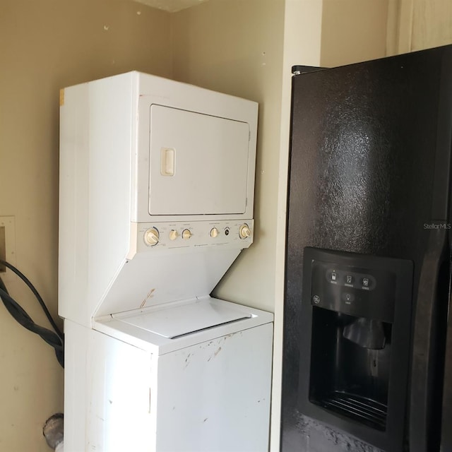 clothes washing area with stacked washer and dryer