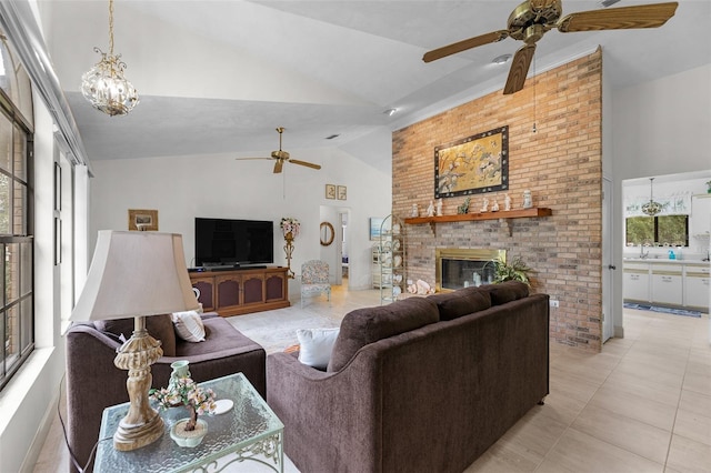 tiled living room featuring a brick fireplace, ceiling fan with notable chandelier, and high vaulted ceiling