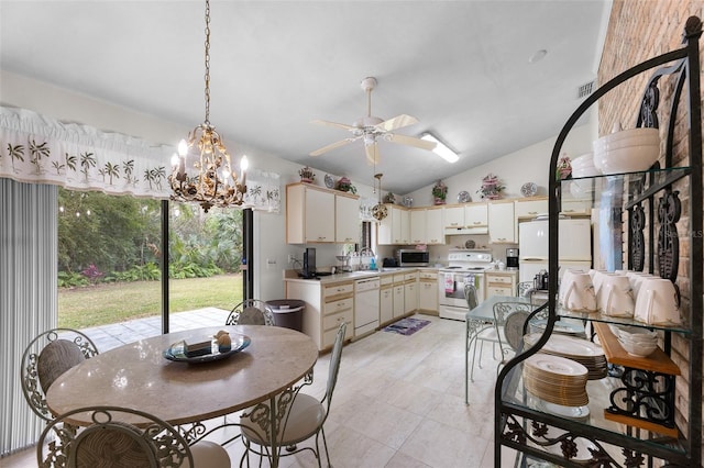 kitchen featuring vaulted ceiling, pendant lighting, sink, cream cabinets, and white appliances