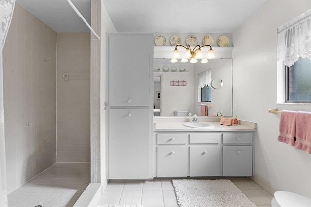 bathroom featuring toilet, tile patterned floors, vanity, and tiled shower