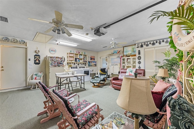 carpeted living room featuring washer / clothes dryer, a textured ceiling, and ceiling fan