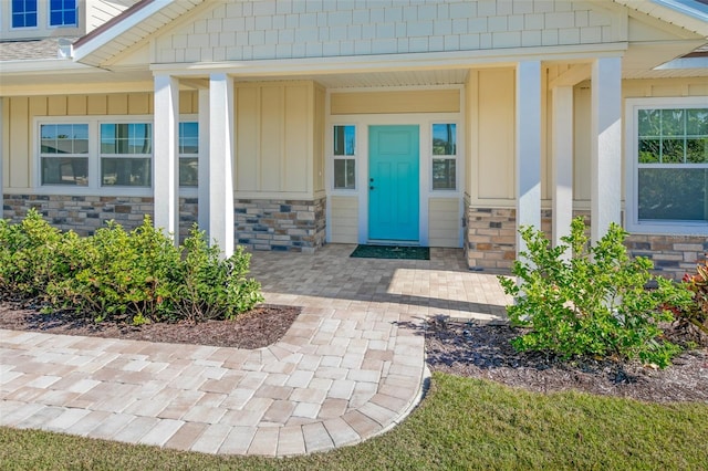 property entrance with stone siding and board and batten siding