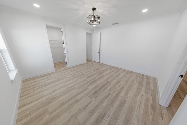 unfurnished room with light wood-style floors, baseboards, a notable chandelier, and recessed lighting