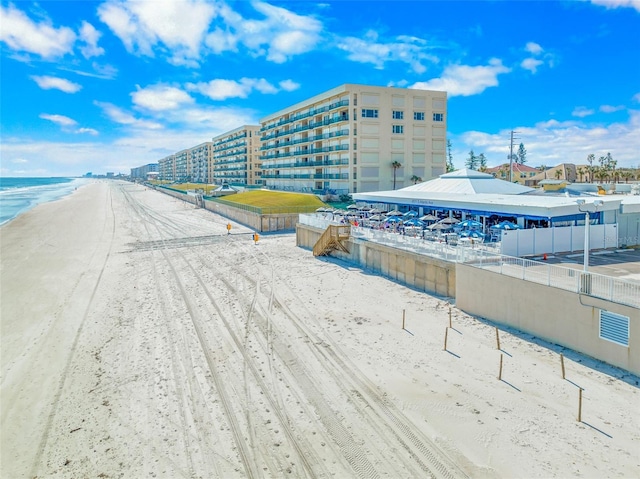 view of property's community with a water view and a beach view