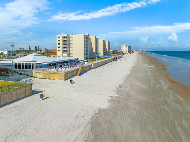 birds eye view of property with a water view and a beach view