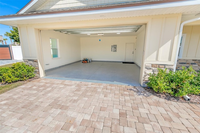 garage with decorative driveway and electric panel