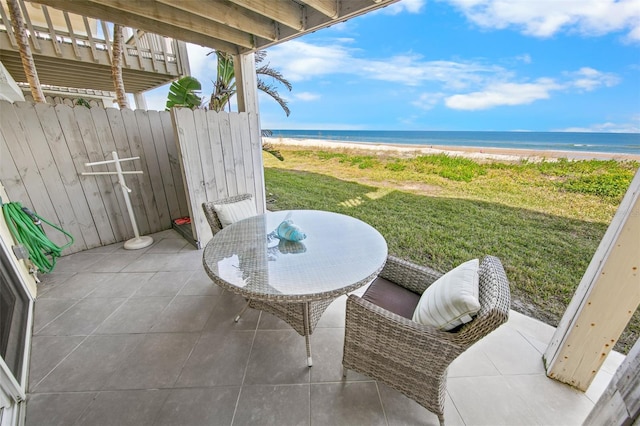 view of patio / terrace with a water view and a view of the beach