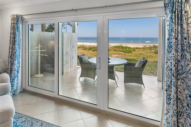 doorway to outside with crown molding, a water view, and light tile patterned floors