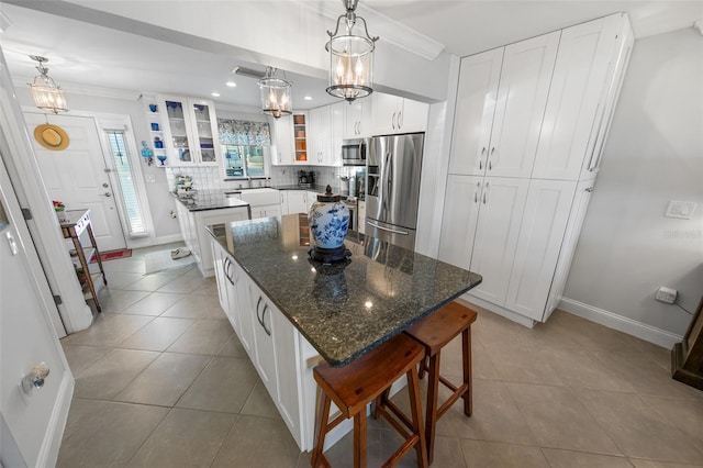 kitchen with a kitchen island, white cabinetry, appliances with stainless steel finishes, and tasteful backsplash