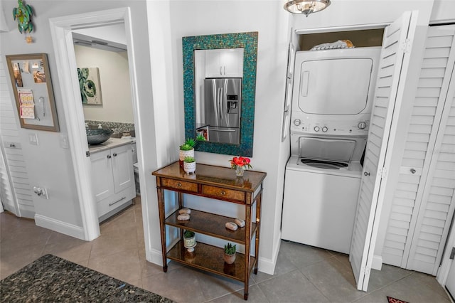 laundry room with sink, stacked washer / drying machine, and light tile patterned floors