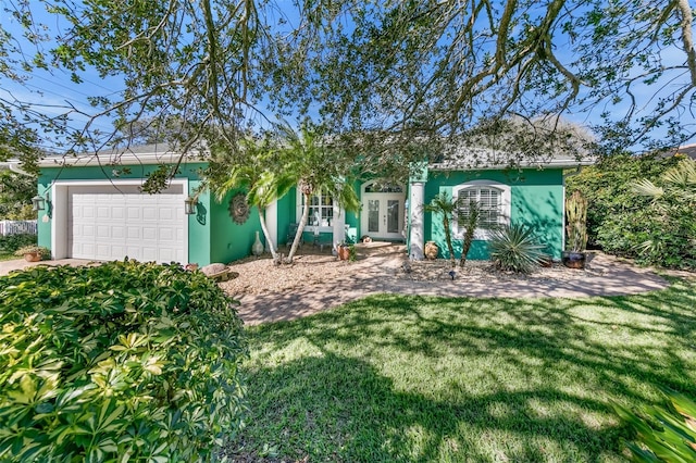 view of front of home featuring a garage, a front yard, and french doors