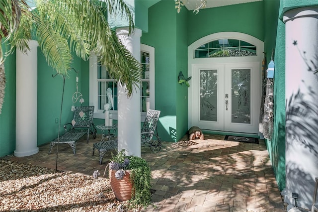 view of exterior entry with a patio area and french doors