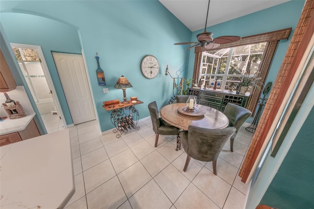 tiled dining area with vaulted ceiling and ceiling fan