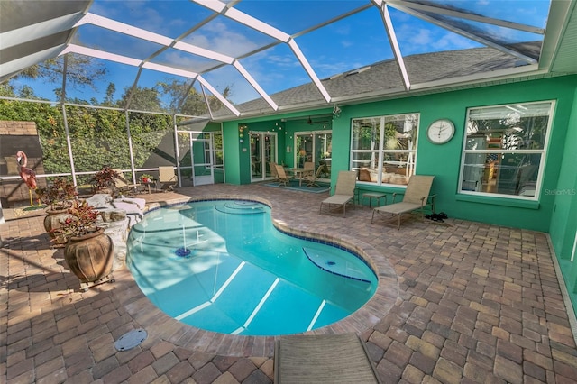 view of swimming pool with a lanai, ceiling fan, and a patio area