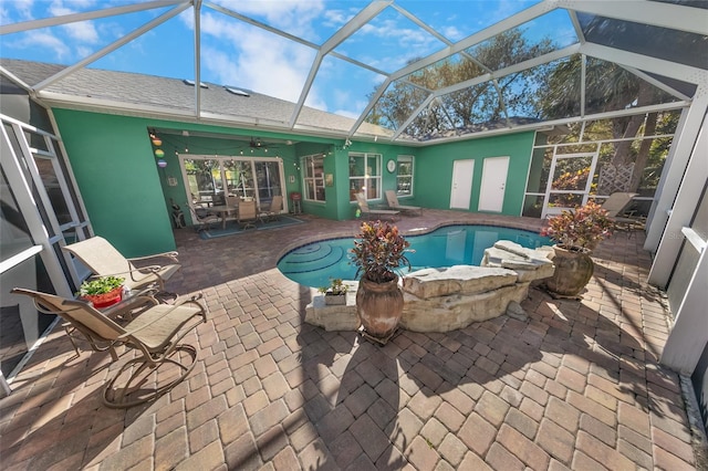 view of pool featuring ceiling fan, a lanai, and a patio area