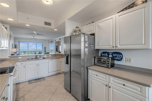 kitchen with white cabinetry, white appliances, sink, and light tile patterned floors