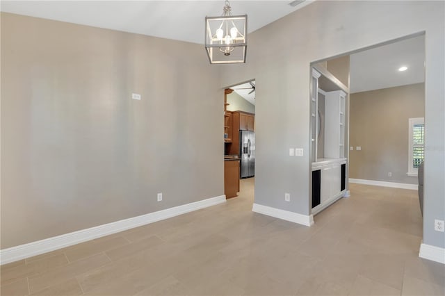 spare room with an inviting chandelier