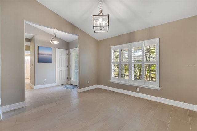 unfurnished room featuring a chandelier and vaulted ceiling