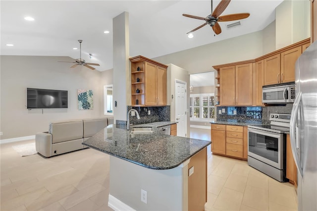 kitchen featuring sink, dark stone counters, ceiling fan, stainless steel appliances, and decorative backsplash