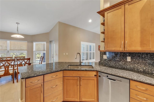 kitchen featuring dark stone countertops, sink, stainless steel dishwasher, and backsplash