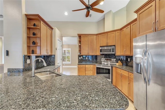 kitchen featuring stainless steel appliances, sink, and dark stone countertops