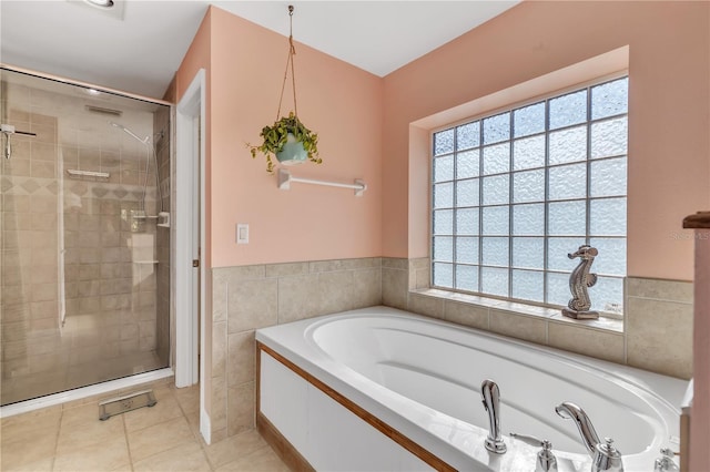 bathroom featuring tile patterned flooring, plus walk in shower, and tile walls