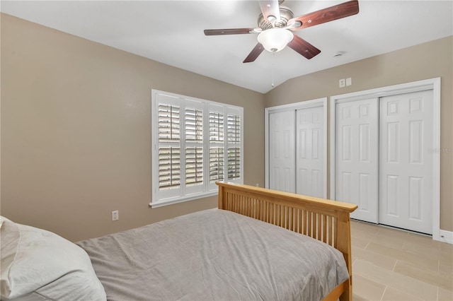 bedroom featuring lofted ceiling, two closets, and ceiling fan