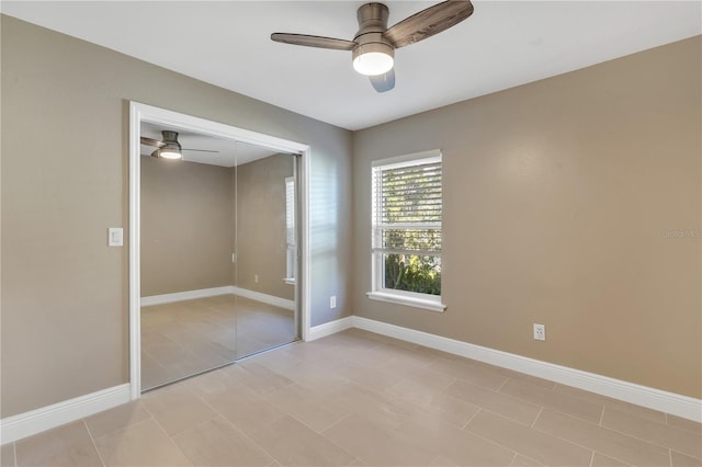 unfurnished bedroom featuring ceiling fan and a closet