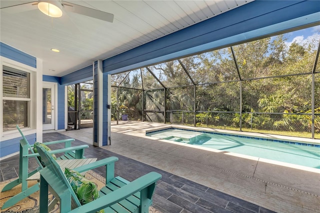 view of pool with ceiling fan, glass enclosure, and a patio