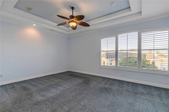 carpeted empty room with ceiling fan and a raised ceiling