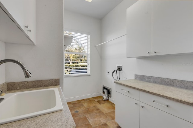 washroom featuring electric dryer hookup, sink, hookup for a washing machine, and cabinets