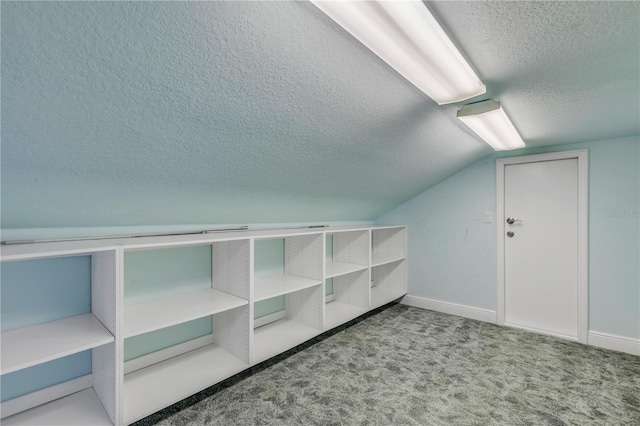 additional living space featuring vaulted ceiling, a textured ceiling, and carpet flooring