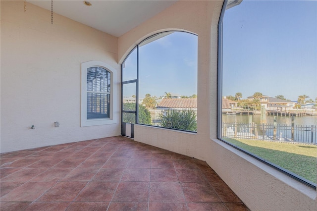 unfurnished sunroom with a water view