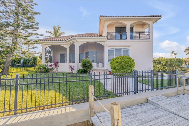 mediterranean / spanish-style home featuring a balcony and a front yard