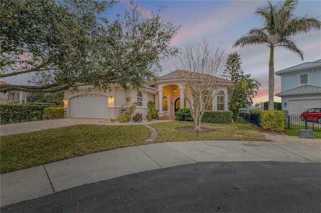 mediterranean / spanish house featuring a yard and a garage