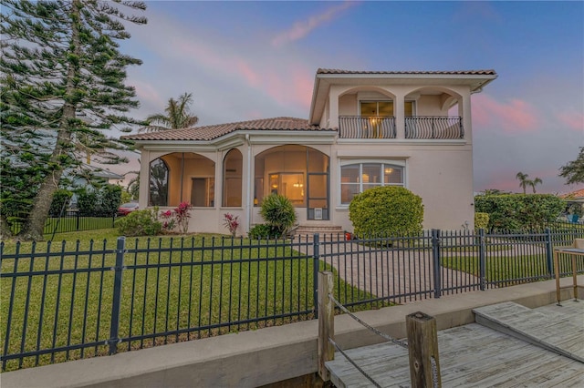 mediterranean / spanish-style home featuring a balcony and a yard