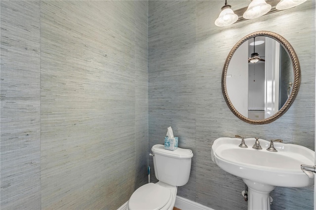 bathroom with ceiling fan, toilet, and sink