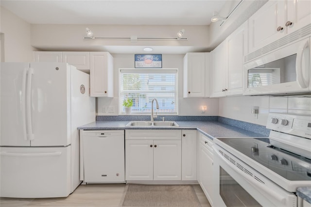 kitchen featuring white cabinetry, white appliances, a healthy amount of sunlight, and sink