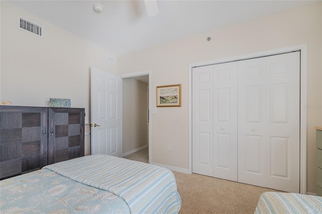 carpeted bedroom with ceiling fan and a closet