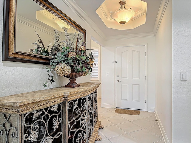 foyer with baseboards, a tray ceiling, light tile patterned flooring, and crown molding